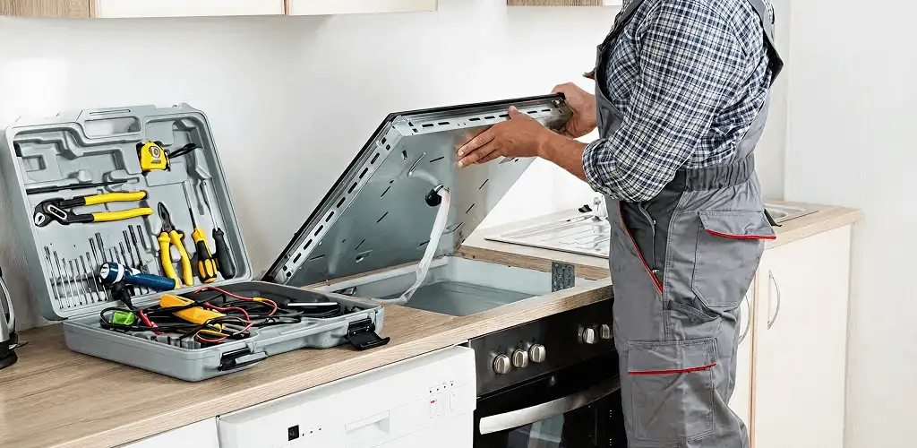 Handyman repairing a cooktop and checking wiring connections in Lakeland, FL