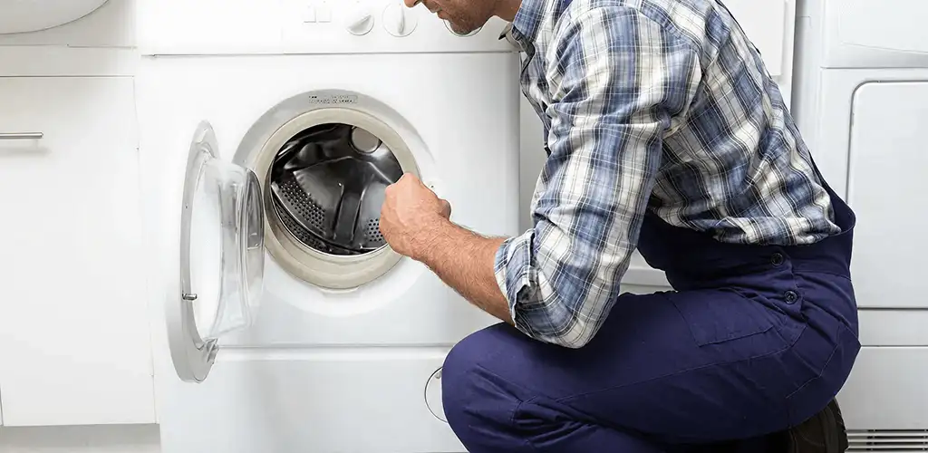 Handyman inspecting a dryer drum and internal parts for repair in Lakeland, FL