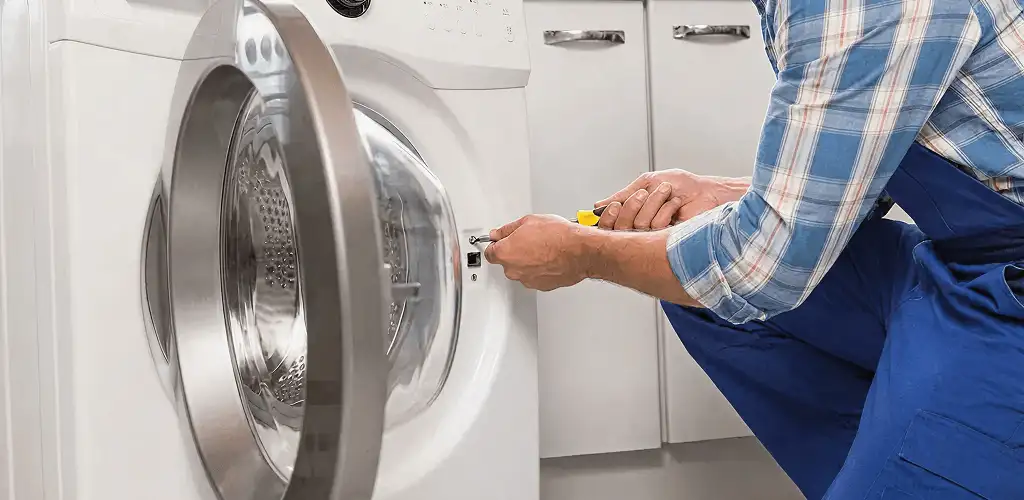 Handyman repairing a clothes dryer and checking electrical connections in Lakeland, FL