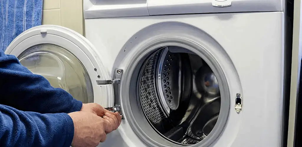 Washing machine repair handyman checking a front-load washer door and latch in Lakeland, FL