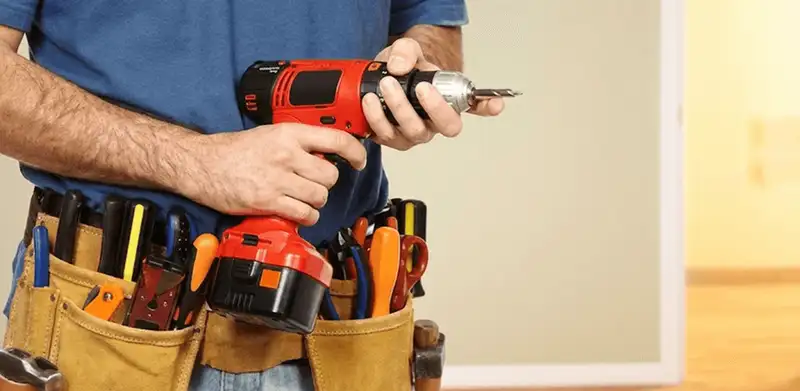 Handyman holding a power drill for home repairs and installations in Lakeland, FL