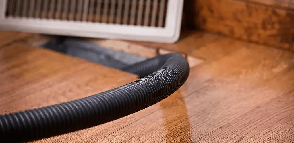 Air duct cleaning hose inserted into a floor vent for ductwork cleaning in Lakeland, FL