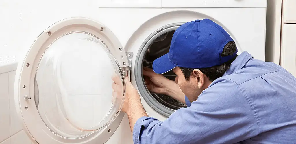 Washing machine repair handyman inspecting a front-load washer drum in Lakeland, FL